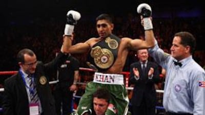 Amir Khan holds his gloved hands aloft after beating Dmitriy Salita in just 76 seconds.
