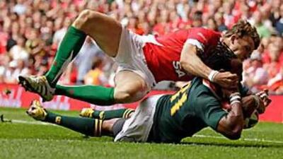 South Africa's Odwa Ndungane, in green, scores a try past Tom Prydie, of Wales, during their Test at the Millennium Stadium in Cardiff yesterday. Wales failed to beat an under-strength Springboks side.