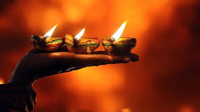 Light handed: a devotee holds earthen lamps during the annual Festival of Lights at the tomb of Sufi poet Shah Hussein in Lahore, Pakistan. Rahat Dar / EPA