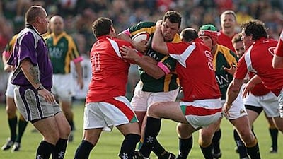 A member of the South African Legends is tackled by British Legends players.