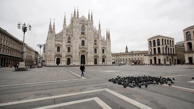 A woman crosses a nearly empty Duomo square in downtown Milan, Italy. AP Photo