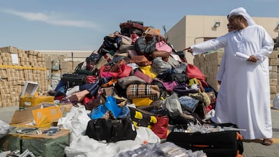 Ibrahim Behzad, Director of Intellectual Property Rights Management at DED looks through a pile of counterfeit products at the DED in Al Garhoud. The products are scheduled to be distroyed and recycled. Antonie Robertson / The National