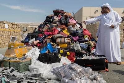 Ibrahim Behzad, Director of Intellectual Property Rights Management at DED looks through a pile of counterfeit products at the DED in Al Garhoud. The products are scheduled to be distroyed and recycled. Antonie Robertson / The National