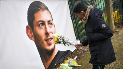 A young man brings flowers in front of the entrance of the FC Nantes football club training center La Joneliere in La Chapelle-sur-Erdre on January 23, 2019, two days after the plane of Argentinian forward vanished during a flight from Nantes in western France to Cardiff in Wales. The 28-year-old Argentine striker is one of two people still missing after contact was lost with the light aircraft he was travelling in on January 21, 2019 night. Sala was on his way to the Welsh capital to train with his new teammates for the first time after completing a £15 million ($19 million) move to Cardiff City from French side Nantes on January 19. / AFP / LOIC VENANCE
