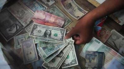 A currency trader at his roadside stall in Karachi. The Pakistani rupee continues to decline against international currencies. Asif Hassan / AFP