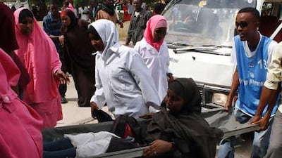 An injured woman is carried to Medina hospital as fighting rages in Mogadishu after Al Qa'eda-inspired extremists launched an offensive.