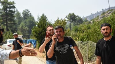 People watch the fire spread in Sirtkoy after fleeing their homes in the village.
