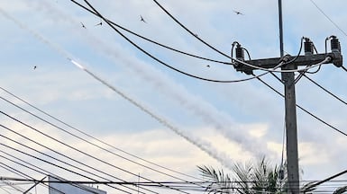 A rocket and smoke trails from a multiple rocket launcher are seen in the sky during clashes along the Cambodia-Thailand border in Cambodia's Oddar Meanchey province. AFP