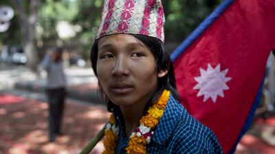 A boy carries the national flag of Nepal during a protest in New Delhi, India. Tsering Topgyal / AP Photo