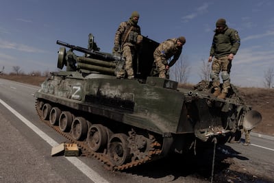 Ukrainian soldiers stand on top of a Russian artillery vehicle they captured during fighting outside Kharkiv. Reuters