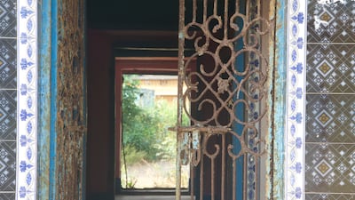 Name plates still hang outside the neatly painted entrances; inside tattered clothes and slippers strewn on the floor—a remnant of their former owners—with walls still adorned with beautiful hand painted vines.