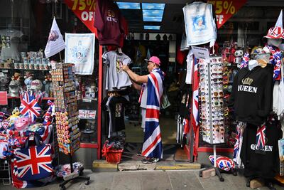 A man draped in a Union Jack flag looks around in a souvenir shop in London. AFP