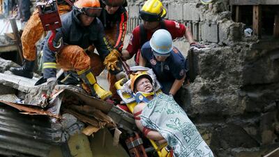 Rescuers lower a resident after being pulled out from the rubble when a wall collapsed at an informal settlers community in Manila, Philippines. Officials and rescuers say a huge concrete section of the wall collapsed on a few houses below and killed two people and injured a few others. Bullit Marquez / AP photo