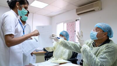 An expatriate nurse takes a coronavirus clearance certificate from a doctor at a health clinic in Subhan, Kuwait on March 9, 2020. REUTERS