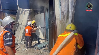 Members of the emergency services hose down a fire in Khan Younis. Reuters
