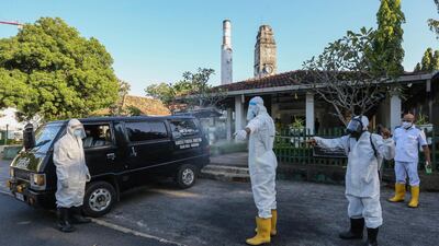 A municipal worker wearing protective gear has his body sprayed with disinfectant after he carried a coffin of Covid-19 coronavirus related victim to the crematorium at the public cemetery in Colombo, Sri Lanka. EPA