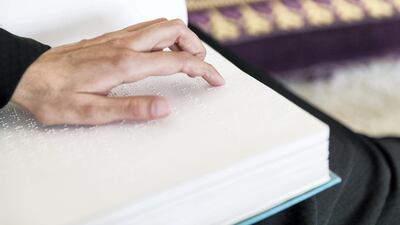 Sameera Al Zaher, who lost her sight last year, reads a Quran in Braille. Reem Mohammed / The National