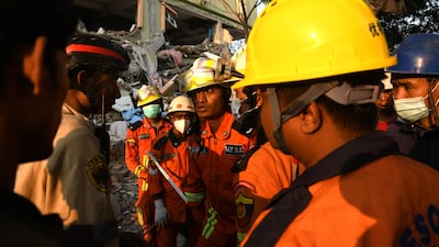 Rescuers search for survivors in the rubble of the Sky Villa Condominium building in Mandalay. AFP