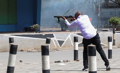 A plainclothes police officer fire teargas to disperse protestors in downtown Nairobi. Reuters