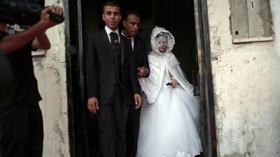 Saed Abu Aser walks with his bride, Falasteen, leaving her family house to go to the wedding hall to celebrate their marriage.