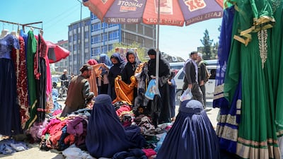 Afghan women shop for clothes at a roadside stall in Kabul. The Taliban has enforced stricter dress codes and other restrictions on women. EPA