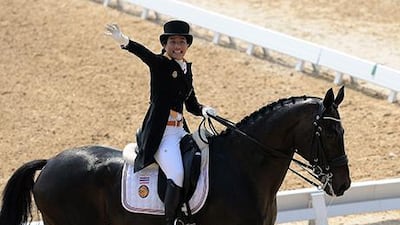 Thai princess Sirivannavari Nariratana, aboard Prince Charming, gestures during the equestrian dressage team competition at Dream Park in Incheon. Prakash Singh / AFP