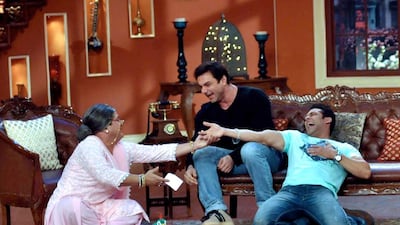 Indian Bollywood film actor Salman Khan (right), with producer and director Sohail Khan (centre), perform during the promotion of the Hindi film Jai ho on the set of the TV Hindi show Comedy Night with Kapil in Mumbai on January 9, 2014. AFP