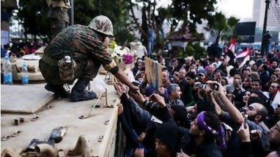 A soldier hands out food to Egyptian protesters taking part in the Million Man March in Cairo's Tahrir Square on February 1. Andrew Henderson / The National