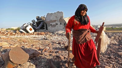 A woman salvages items from a building reportedly destroyed during air strikes by Russia, in the town of Kafranbel in the rebel-held part of Idlib province. AFP / Omar Haj Kadour
