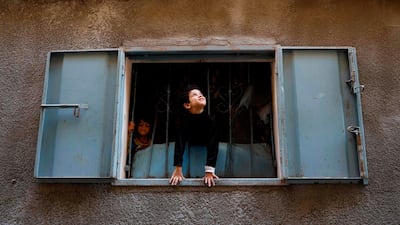 Palestinian boys look out from their family home near the Saint Porphyrios Greek Orthodox Church in Gaza City, which is closed to the public this year due to Covid-19 restrictions. AFP