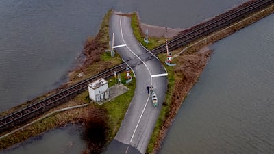 Two men pull their boat over a railroad crossing near Frankfurt, Germany. Fields were flooded by heavy rainfall. AP