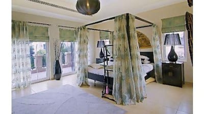 Sliding-glass doors in the airy master bedroom open on to a full-length balcony that overlooks the garden. Courtesy Better Homes