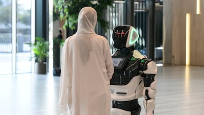 Guests entertained by a robot at the Mohamed bin Zayed University of Artificial Intelligence in Abu Dhabi. Khushnum Bhandari / The National