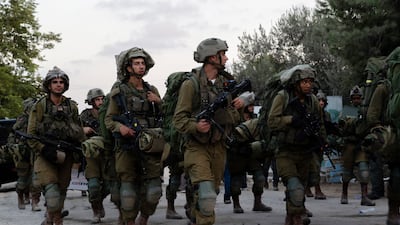 Israeli soldiers walk through Kibbutz Be'eri. Days earlier Hamas militants killed more than a hundred civilians near the border with Gaza. Getty Images