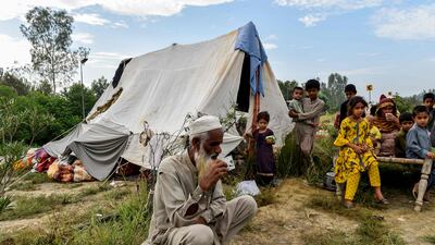 People take refuge by a highway after fleeing from their homes in Charsadda district, Khyber Pakhtunkhwa province. AFP