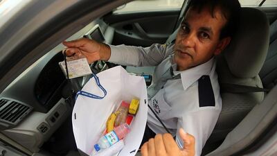Taxi driver Shazad Tariq shows off a Iftar meal he received outside the Royal Meridian Hotel. Sammy Dallal / The National