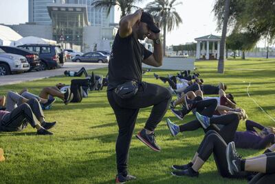 Trainer, Mohamed Zakaria, leads tan exercise session near Nation Towers. Khushnum Bhandari / The National