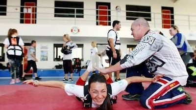 Reyes Fernandez, Groupon director of corporate development, practices for her jump with skydiving instructor Carl Partington. Skydive Dubai and Groupon teamed up to raise money for the UN World Food Programme through an initiative called Jump for Yemen in Dubai. Sarah Dea / The National