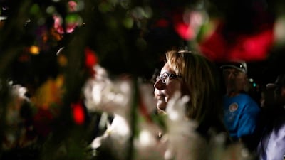 Former US Representative Gabby Giffords places a rose on a wall during the dedication of a healing garden. EPA