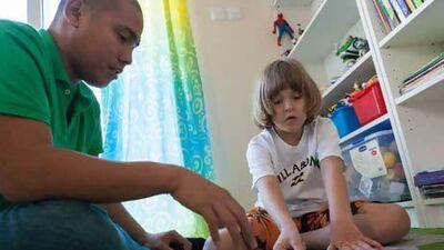 Pedro Markus is helped by senior therapist James Diquiatco, from the Child Early Intervention Centre and Medical Centre, at his home in Dubai.