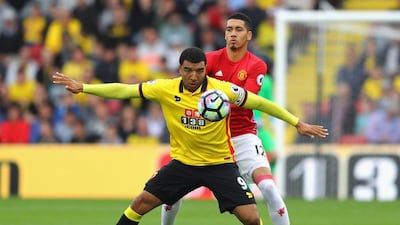 Troy Deeney of Watford, left, and Chris Smalling of Manchester United battle for possession. Richard Heathcote / Getty Images