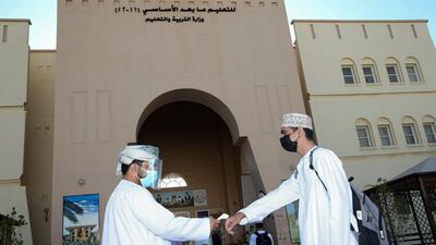A staff member takes the temperature of students arriving to school on the first day of the new academic year at Imam Jaber Bin Zaid secondary school in Oman's capital Muscat. AFP