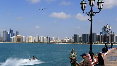 People enjoying a sunny day and warm weather watching jet skiers near flag point on Corniche in Abu Dhabi as skies clear up after the previous day's non-stop rain. Ravindranath K / The National