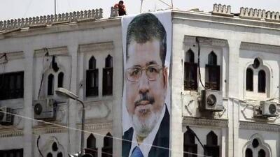 A supporter of deposed Egyptian president Mohammed Morsi reads the Quran on the roof of a building at the Rabaa Adawiya square, Cairo.
