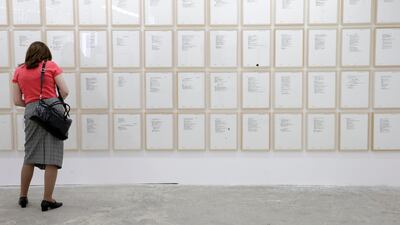 A visitor looks at rewritten pages by the artist Vladimir Miladinovic of the war time diary of former Bosnian Serb general Ratko Mladic in Belgrade, Serbia, July 1, 2020. EPA