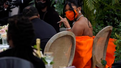 Megan Thee Stallion matvched her bright orange Dolce & Gabbana dress with her mask. AP