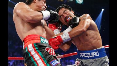 Juan Manuel Marquez, left, and Manny Pacquiao,right, trade blows during their WBO world welterweight fight. Eric Jamison / AP Photo