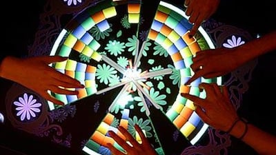 Children play a game on a touch-sensitive digital table by Microsoft at the CeBIT Technology Fair.