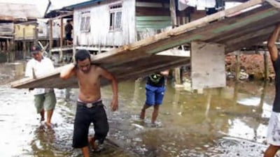 Villagers carry a wall of their traditional wooden house which collapsed in Tolitoli, Central Sulawesi, on Nov 17 2008.
