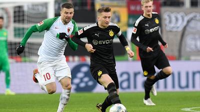 Augsburg midfielder Daniel Baier and Dortmund forward Marco Reus vie for the ball. AFP